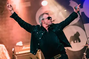 Alex Rosén med armene ut mot publikum på scenen under Hove Rock 2026